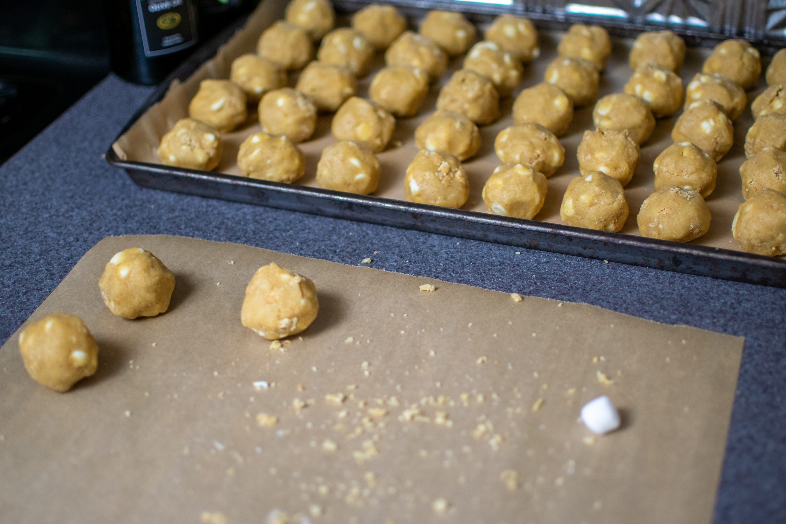 white chocolate s’mores cookie dough portions on a parchment-lined tray