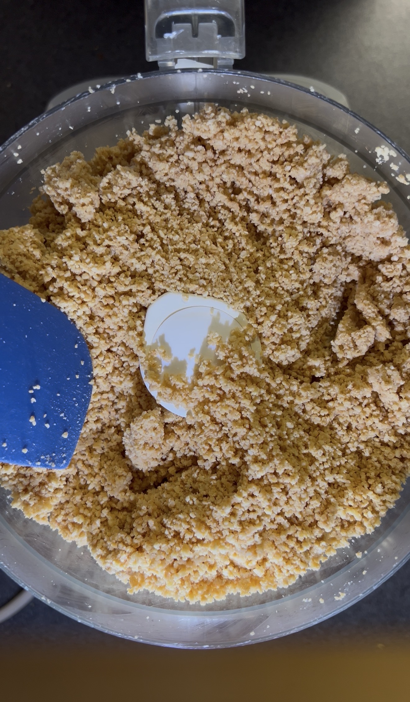 Peanuts blending into homemade peanut butter in a food processor