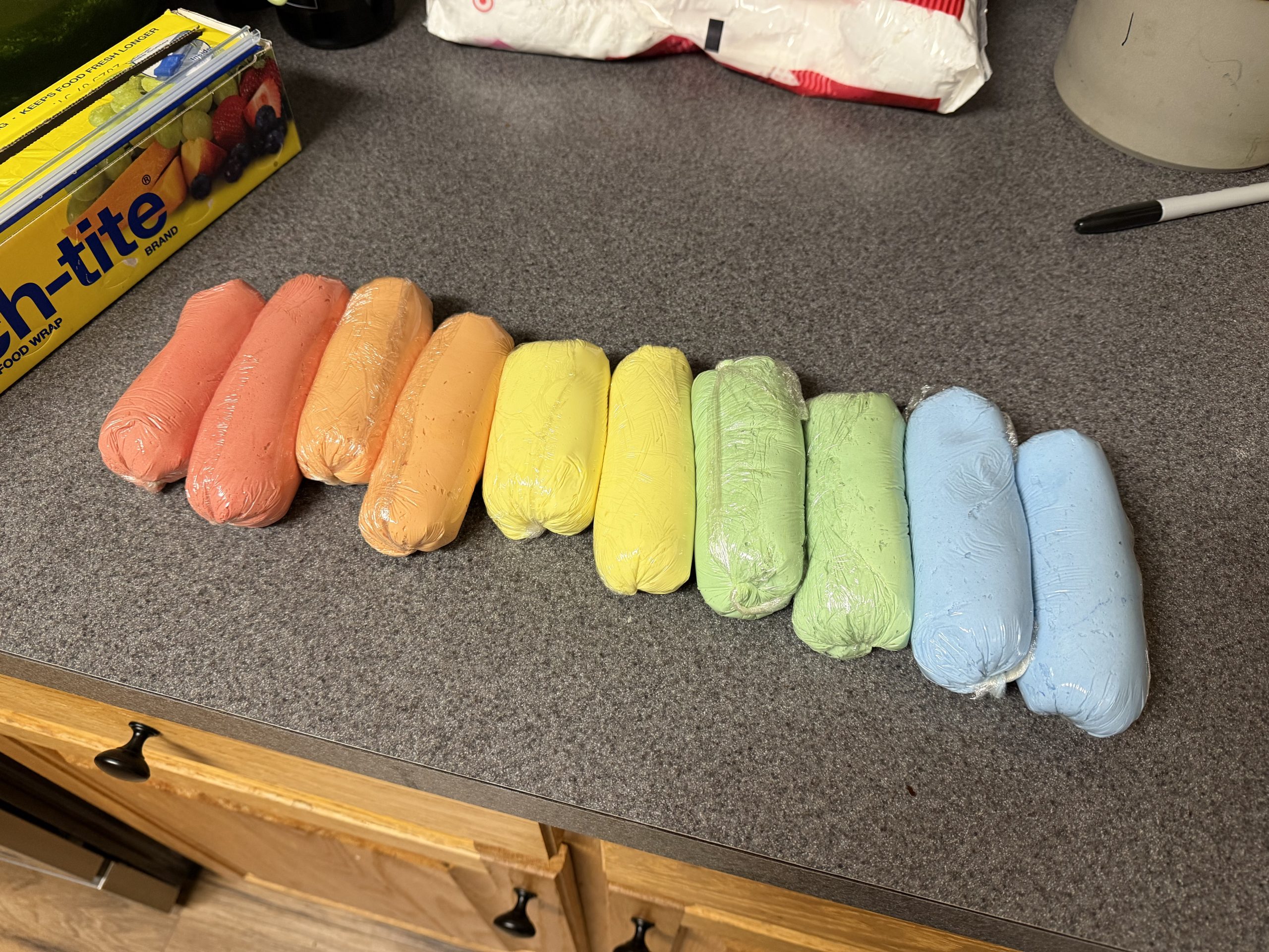 Colored buttercream wrapped into compact logs for overnight storage