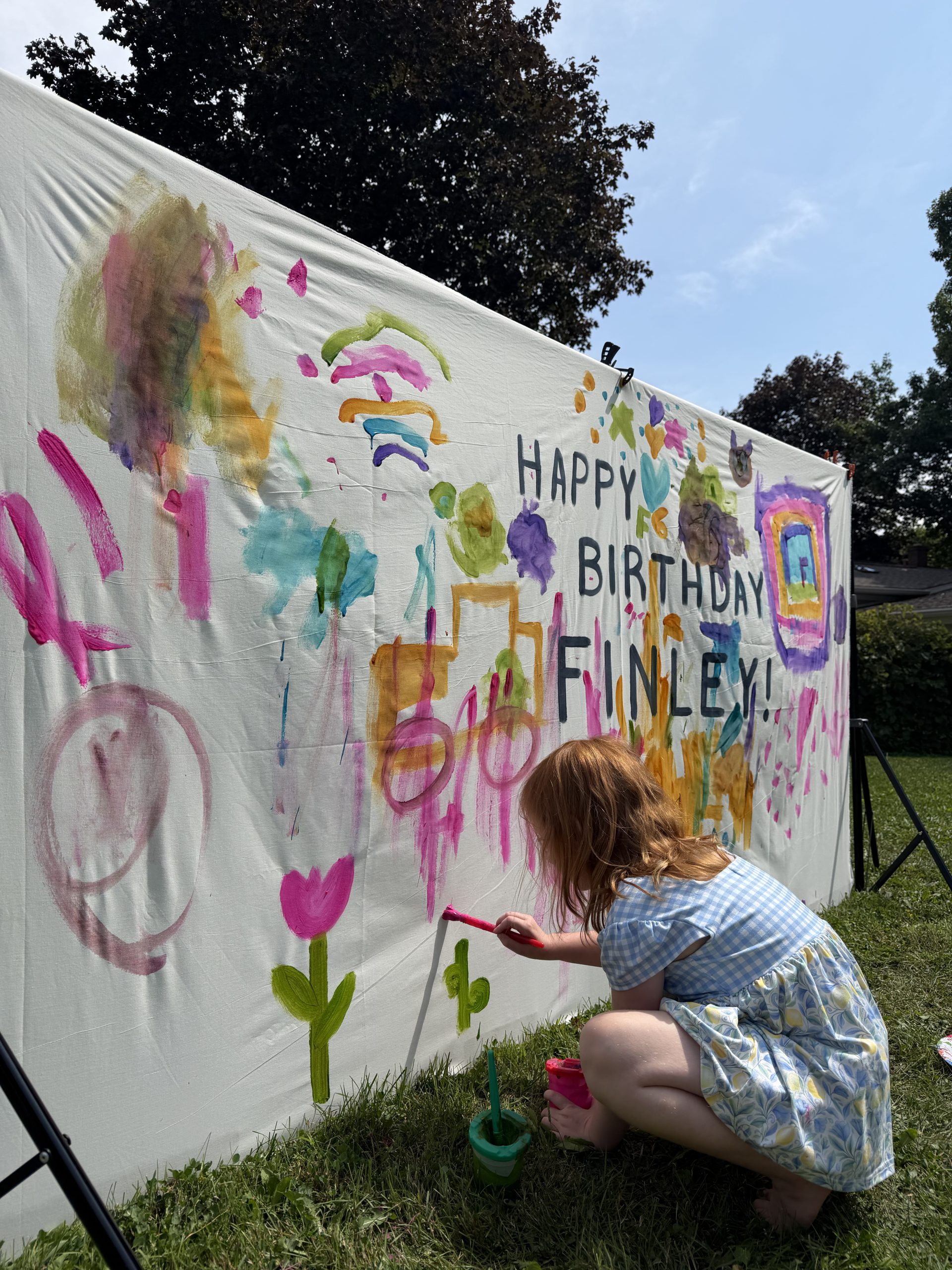 Finley painting the giant collaborative birthday canvas