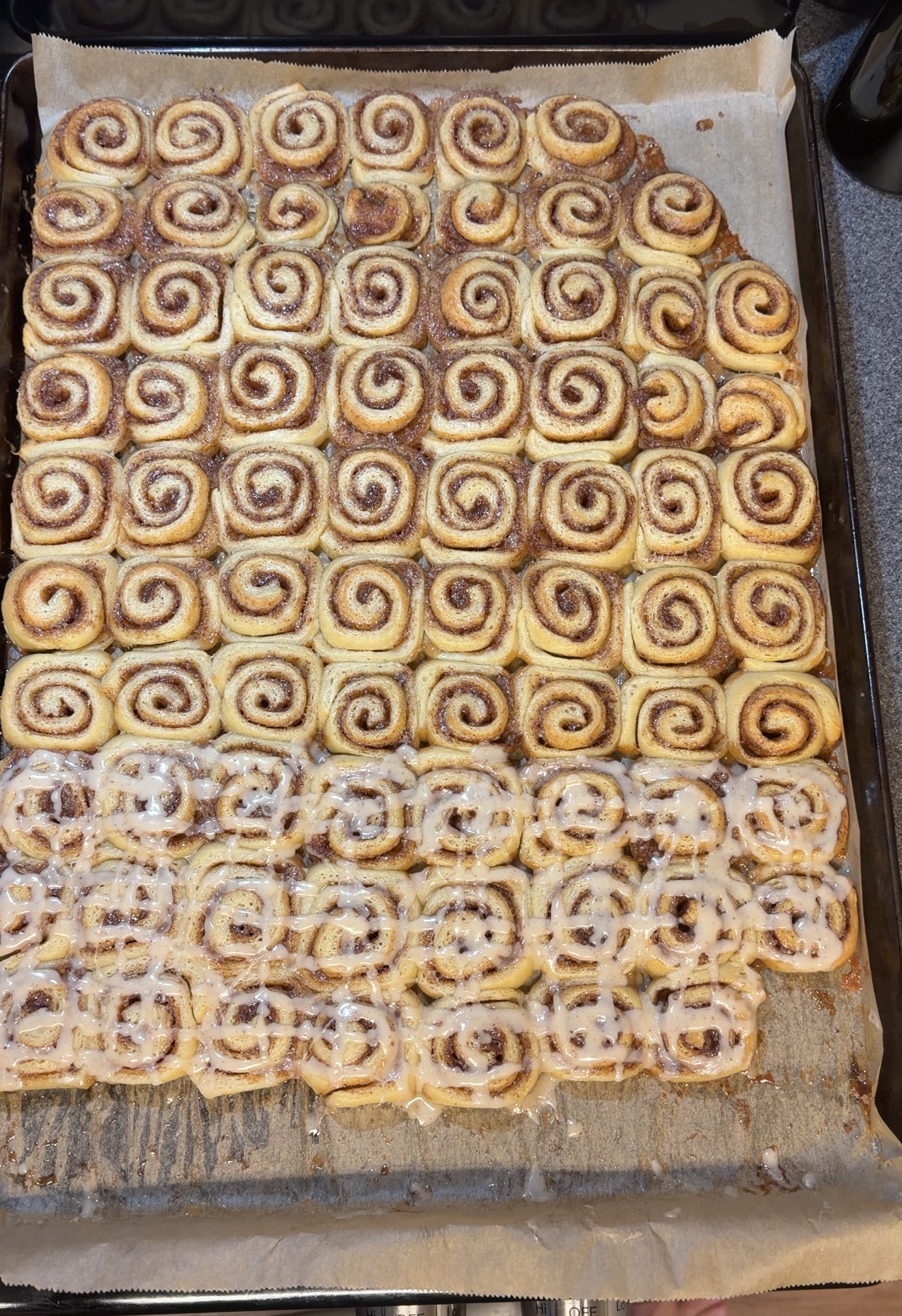 Sheet pan with some mini cinnamon rolls glazed and the freezer portion left plain