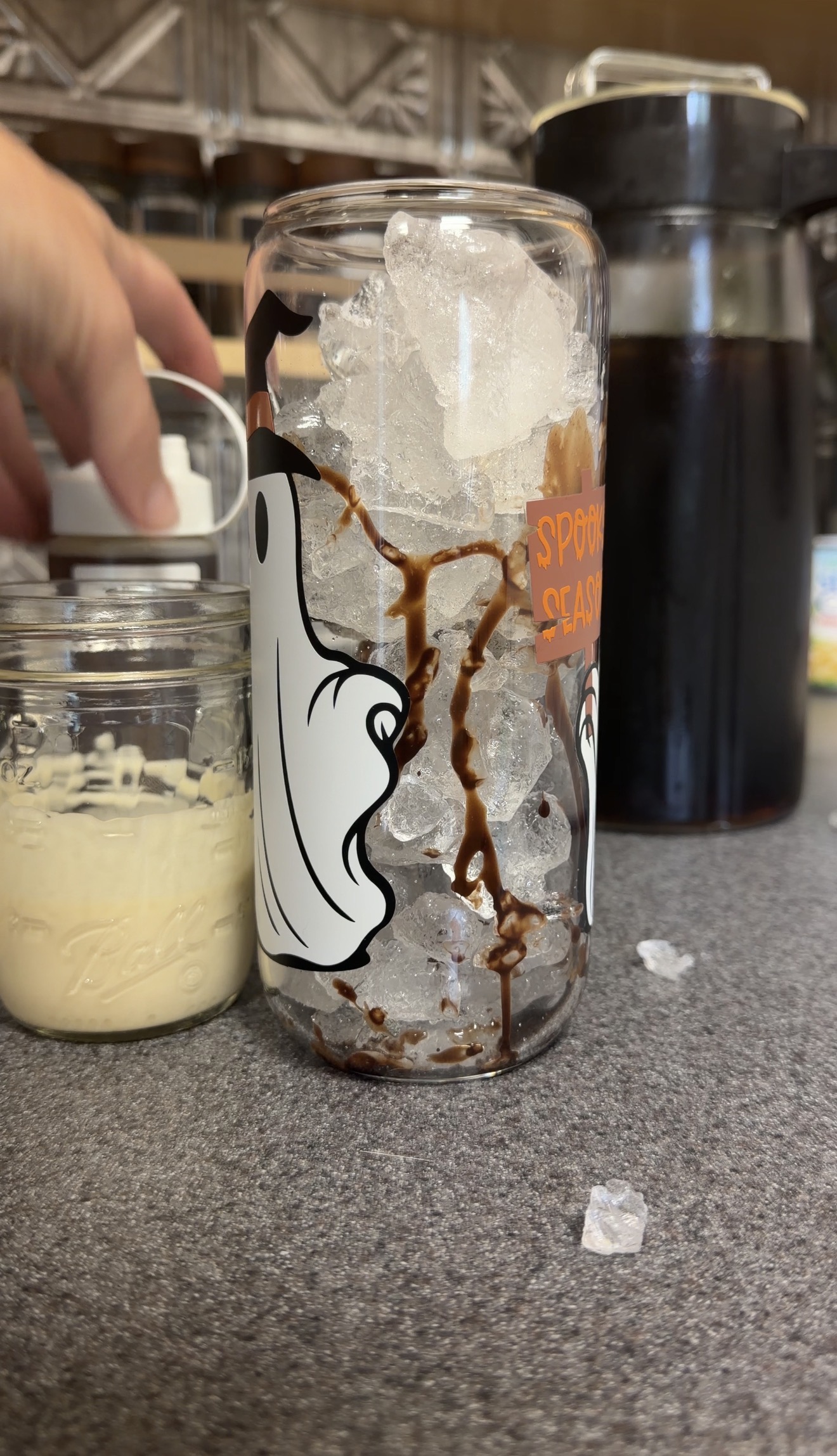 Chocolate syrup drizzled inside a glass filled with ice for S’mores iced coffee.