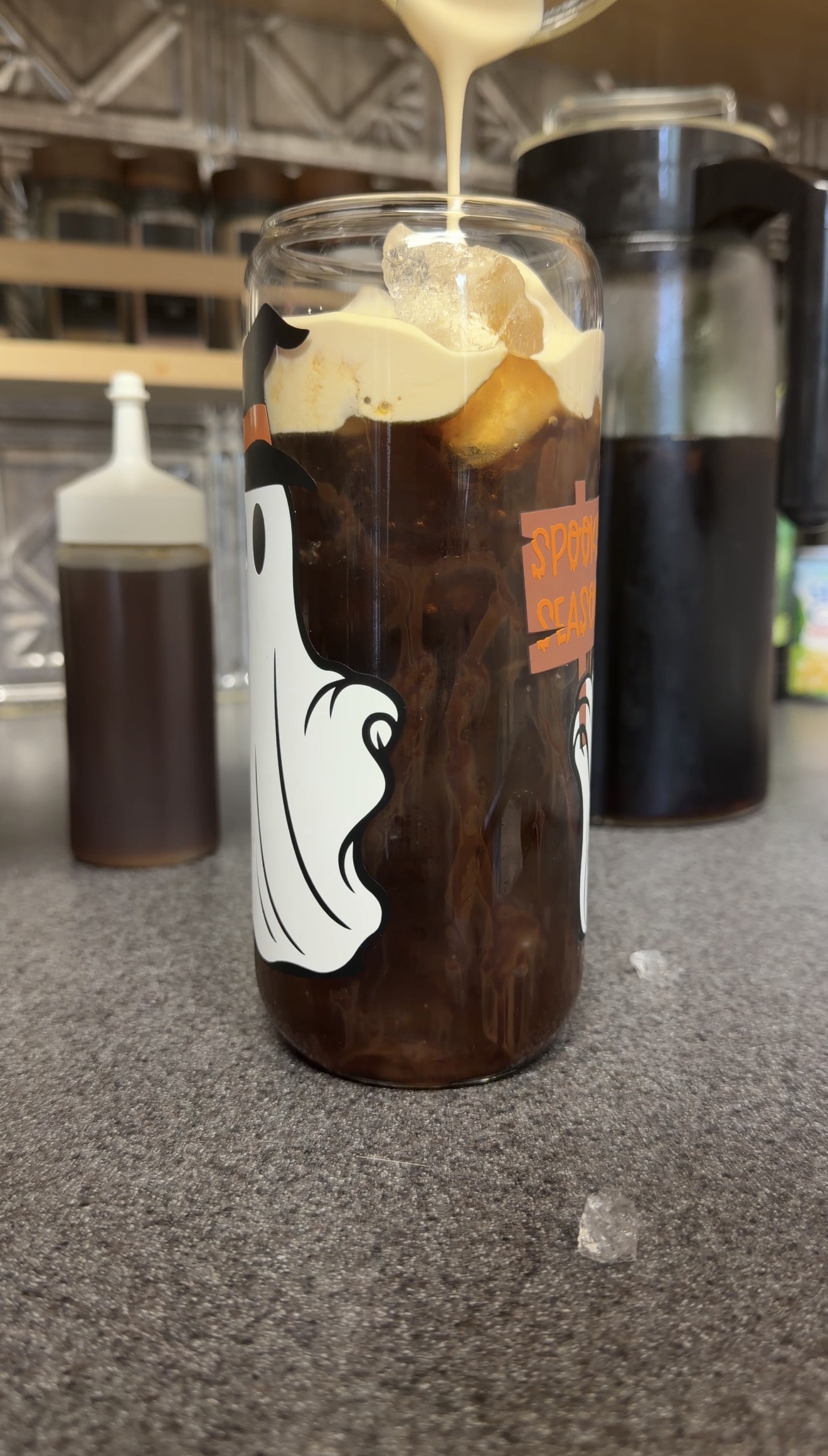 Toasted marshmallow cold foam pouring over homemade S’mores iced coffee.